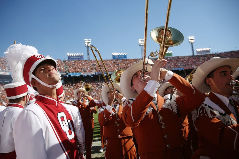 The Texas Longhorns marching band plays near the Oklahoma Sooners band before the Red River...