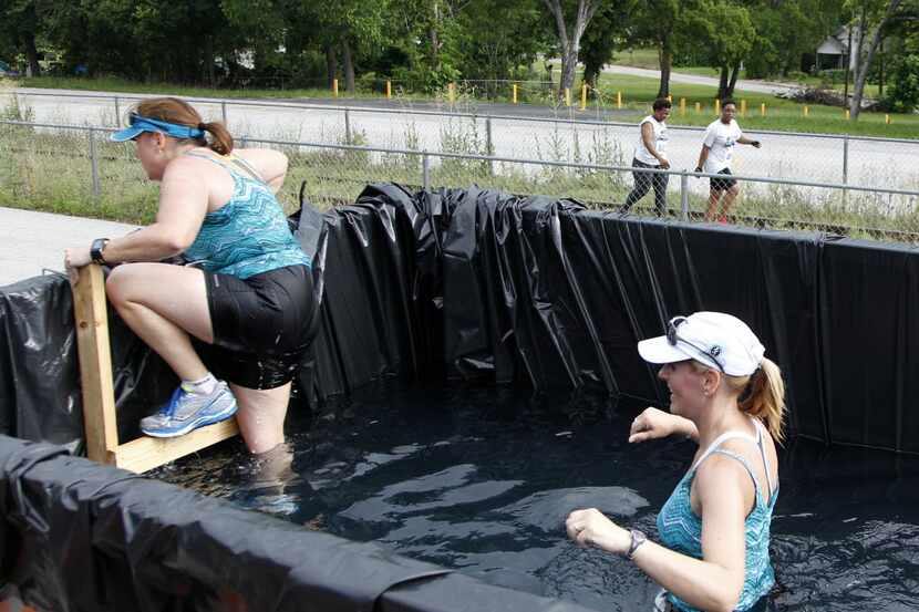 Debbie Sanchez crawls out of a dumpster filled with water as Laurie Buford waits her turn...