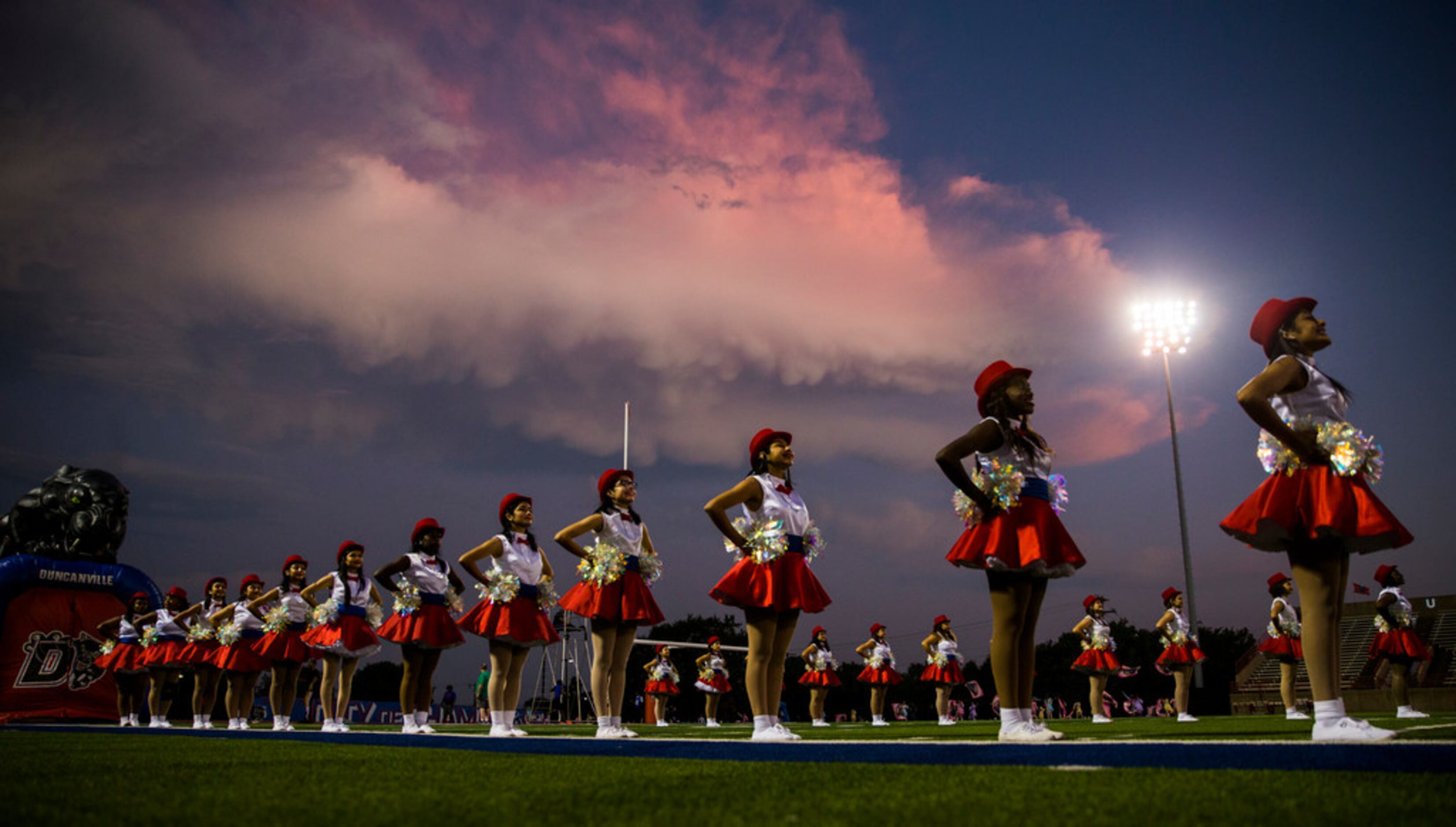 Duncanville dance team members stand at attention before a high school football game between...