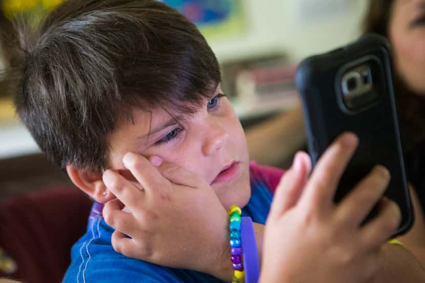 Marilyn Morrison, 9, checks out a smartphone screen at her Grapevine home.