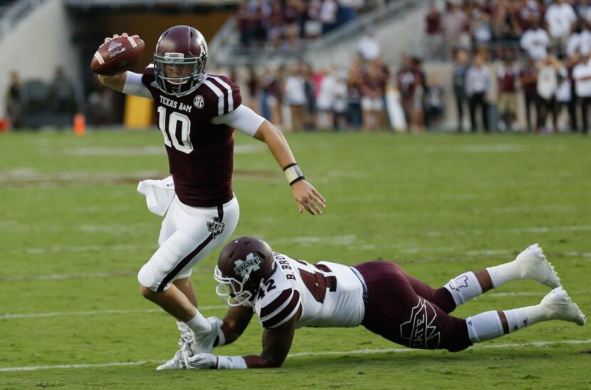 Texas A&M quarterback Kyle Allen (10) avoids the tackle attempt by Mississippi State...