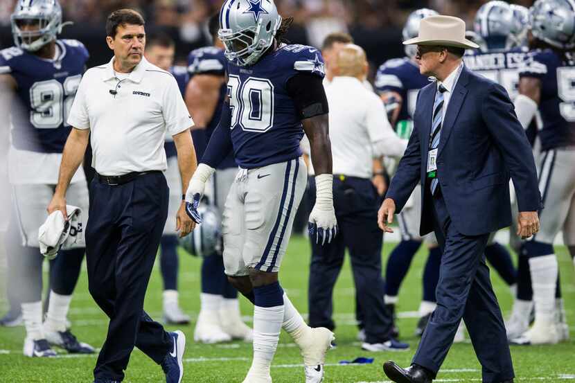 Dallas Cowboys defensive end Demarcus Lawrence (90) is escorted off the field after being...