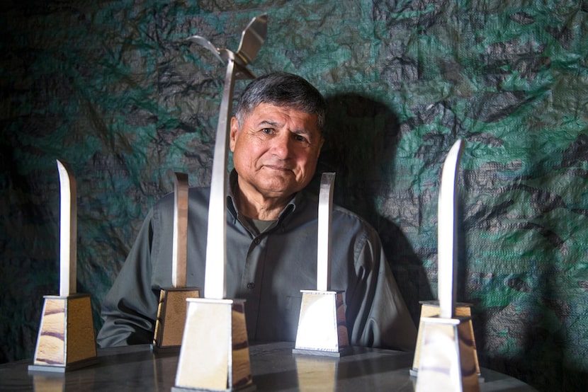 U.S. Army veteran and sculptor Eliseo Garcia poses for a photograph with a model of the...