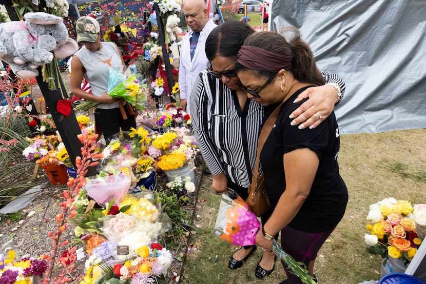 Rose Crayton (left) of Frisco and Paula Willard of McKinney paused at the crosses for...