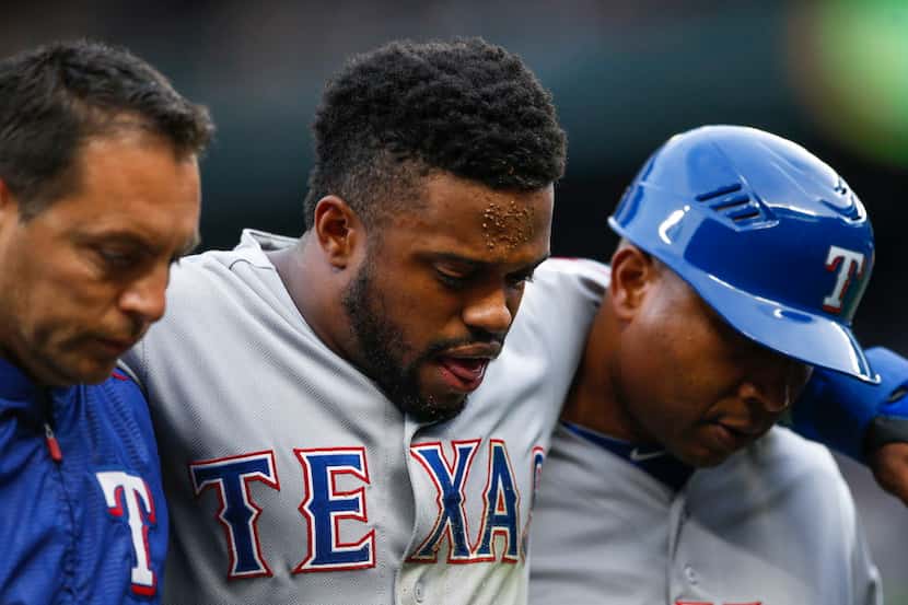 Texas Rangers' Delino DeShields, center, is assisted off the field after suffering an injury...