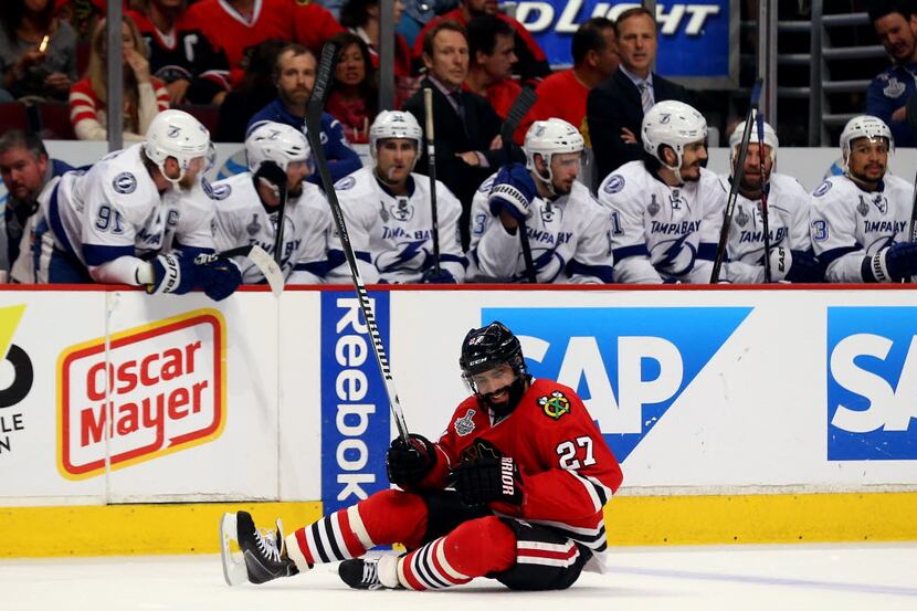 Johnny Oduya #27 of the Chicago Blackhawks reacts after a check against the Tampa Bay...