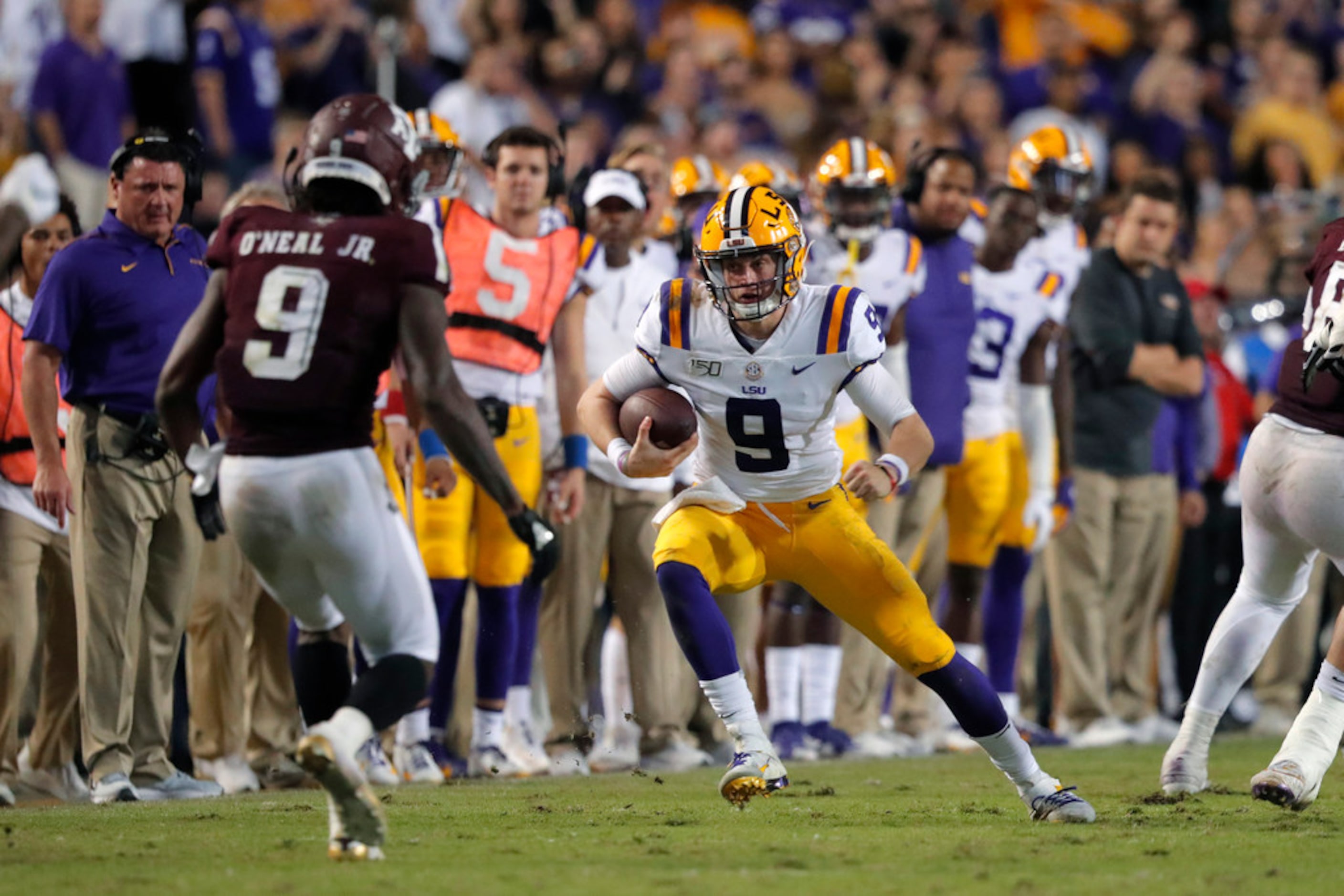 LSU quarterback Joe Burrow (9) carries against Texas A&M defensive back Leon O'Neal Jr. (9)...