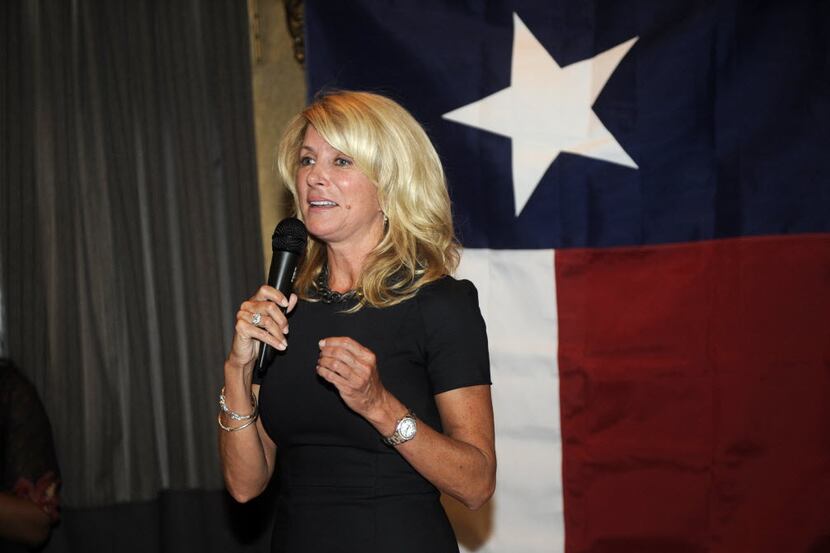 Democratic gubernatorial candidate Wendy Davis gives a high-five to Sam Peters, 12, after...