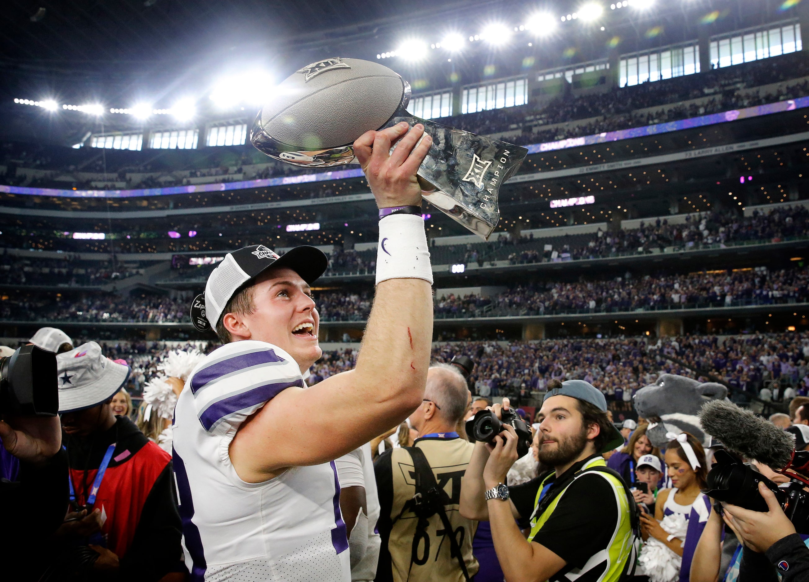 Kansas State Wildcats quarterback Will Howard (18) raises the Big XII Championship trophy...