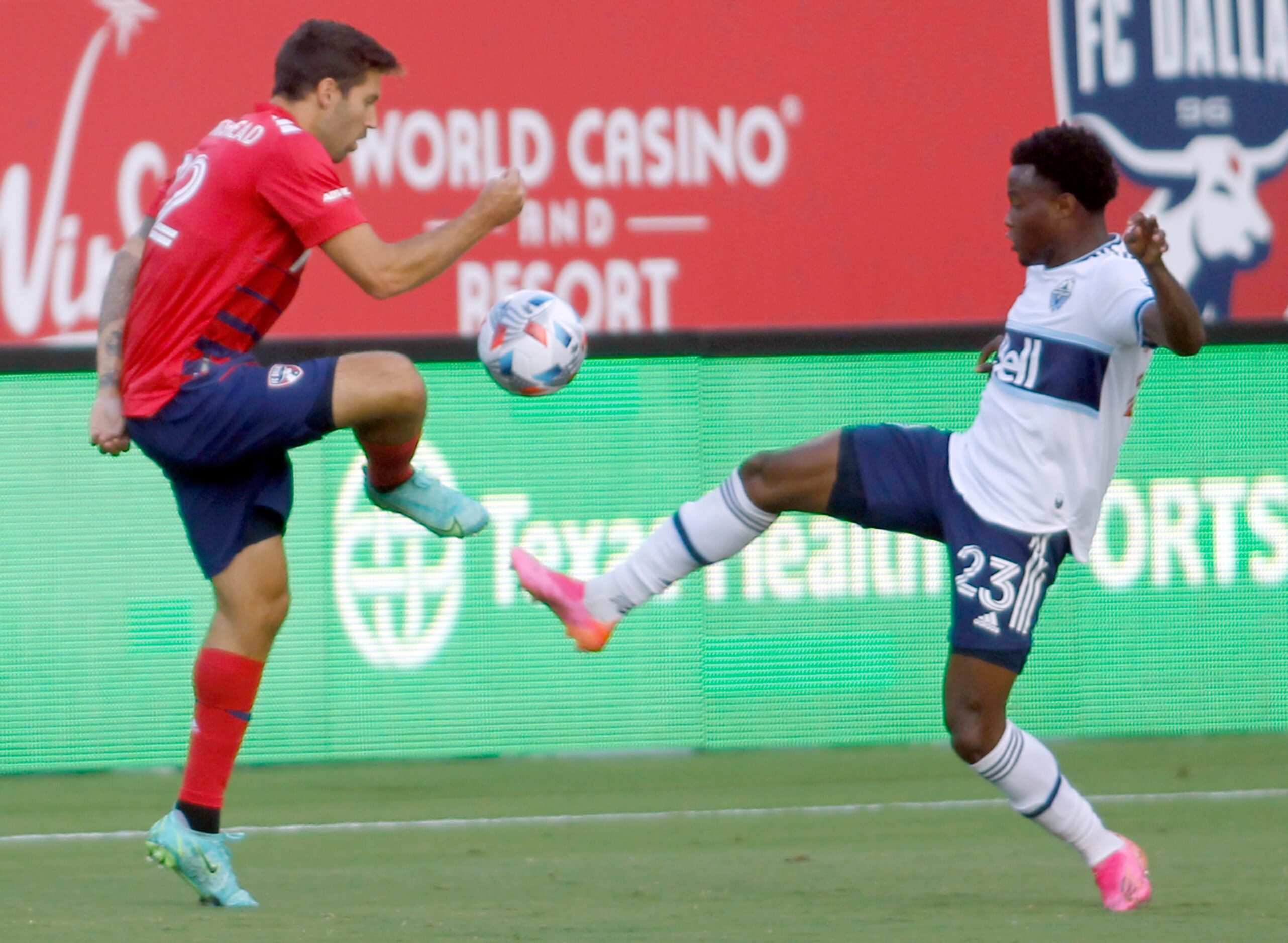 FC Dallas defender Ryan Hollingshead (12), left, challenges Vancouver defender Javain Brown...