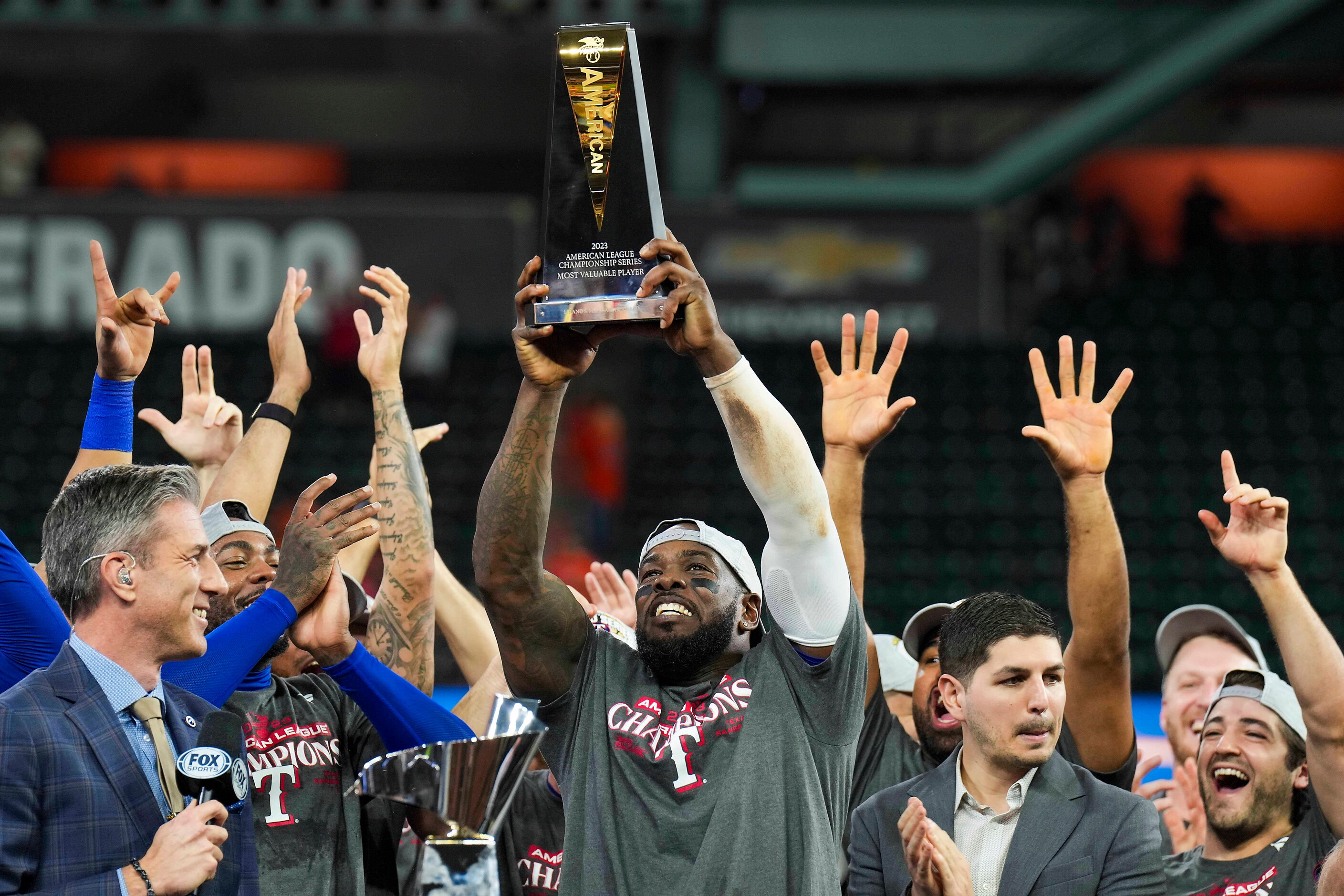 Texas Rangers right fielder Adolis Garcia  hoists the ALCS MVP trophy after defeating the...