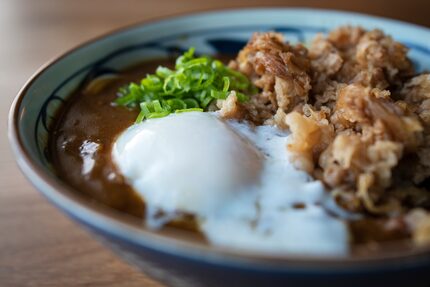 A bowl of curry nikutama is made with seasoned sweet beef, soft egg and curry sauce at...