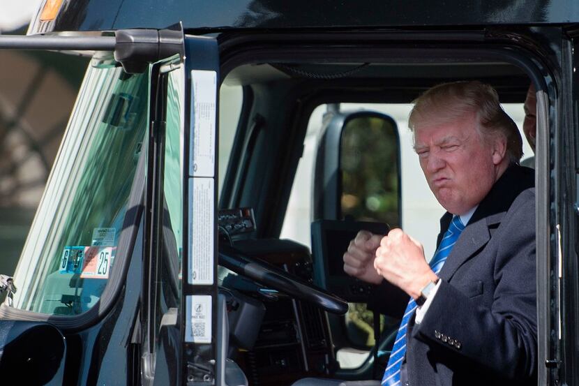 President Donald Trump sits in the drivers seat of a semi-truck as he welcomes truckers and...