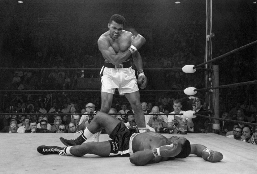 FILE - In this May 25, 1965, file photo, heavyweight champion Muhammad Ali stands over...