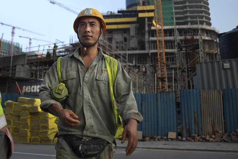 Chinese construction workers on site working at a new shopping mall called The Mall at One...