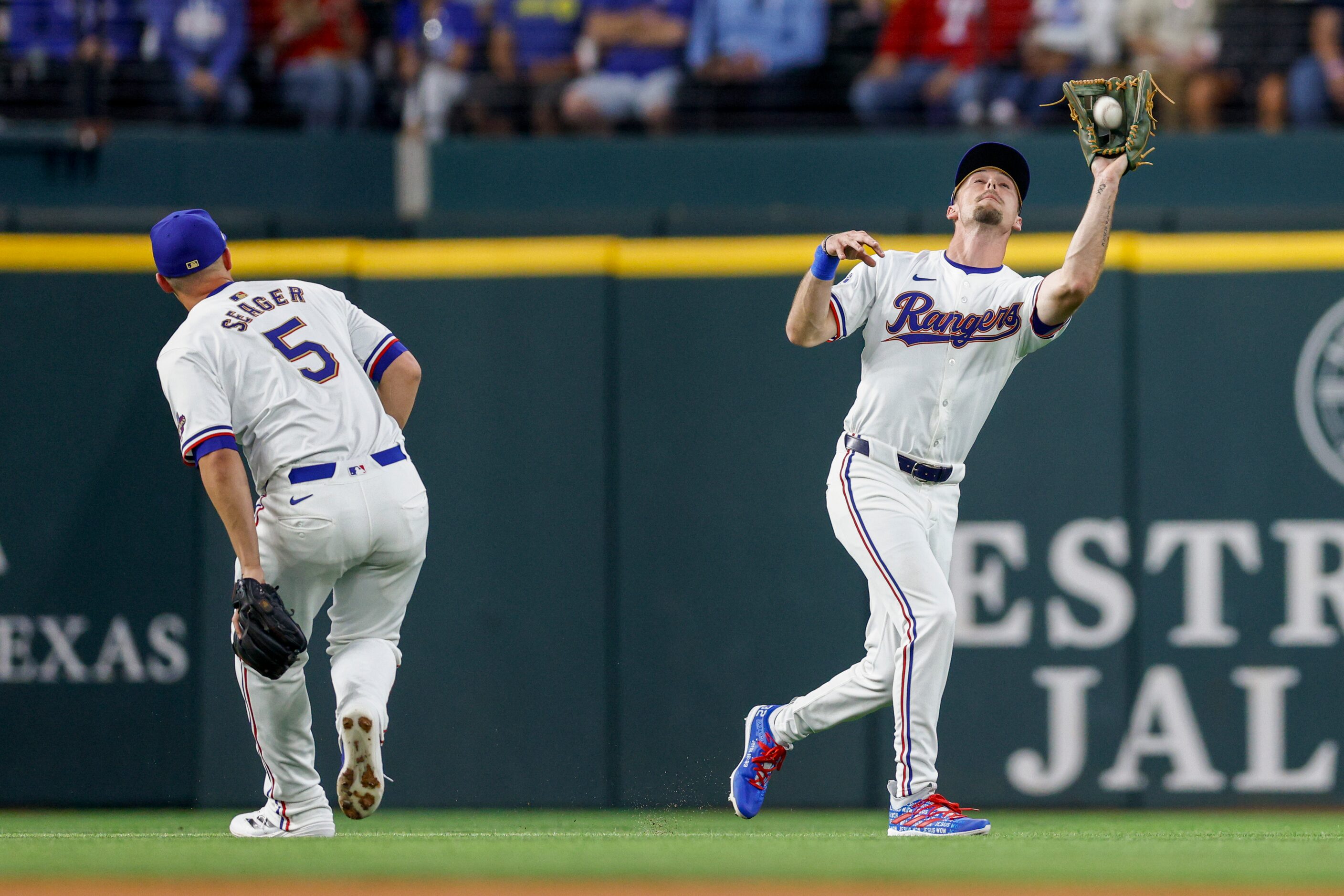 Texas Rangers shortstop Corey Seager (5) ducks out of the way as left fielder Evan Carter...