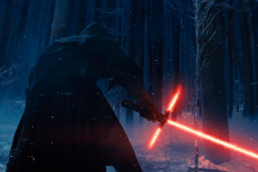 This photo provided by Disney shows, Adam Driver as Kylo Ren with his Lightsaber in a scene...