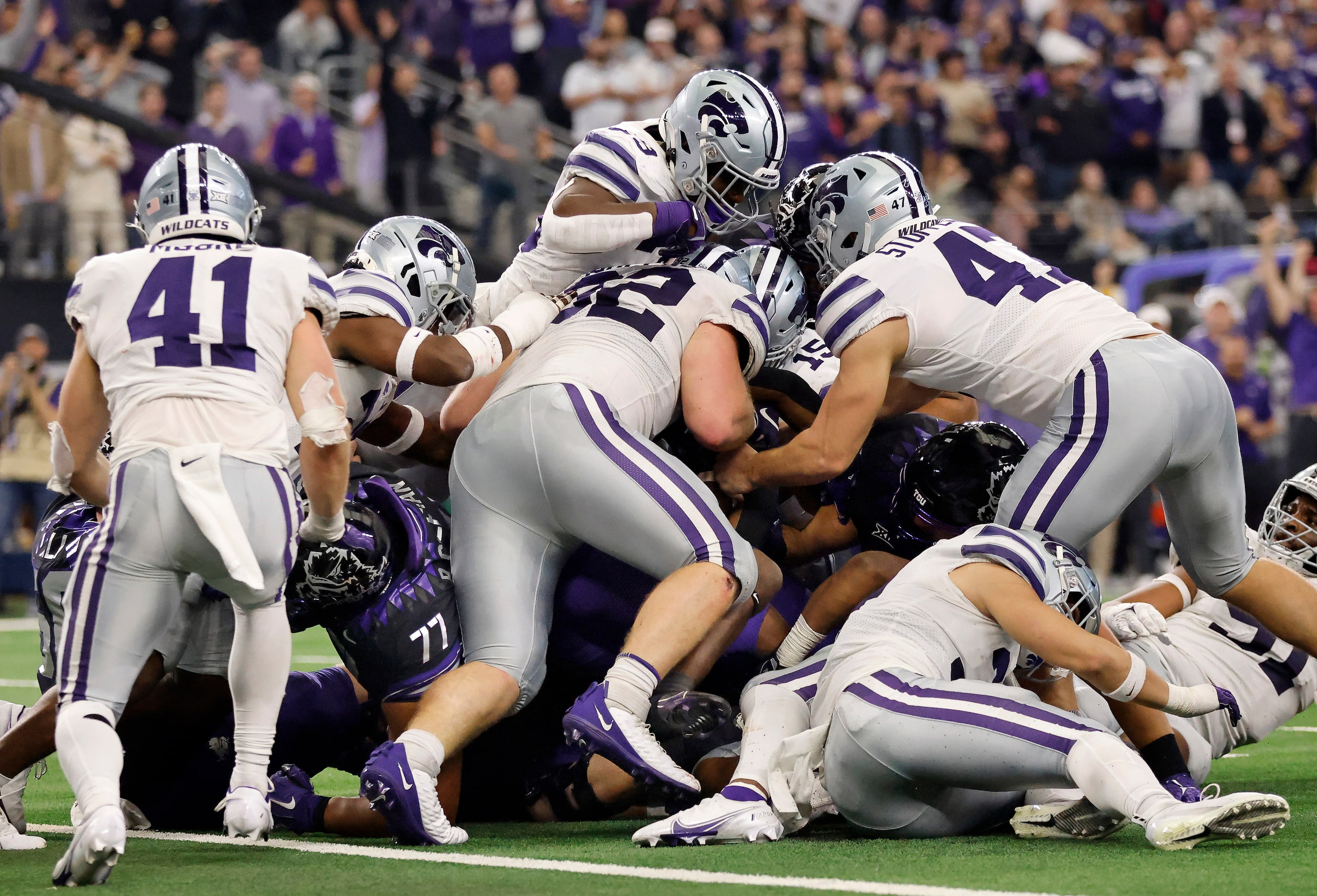 TCU Horned Frogs running back Kendre Miller (33) is buried by the Kansas State Wildcats...