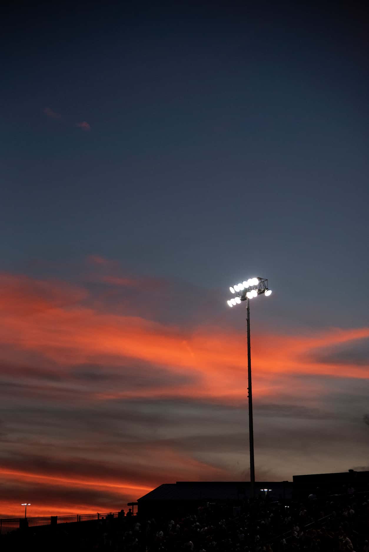 The stadium lights shine bright as the sun sets during South Grand PrairieÕs game against...