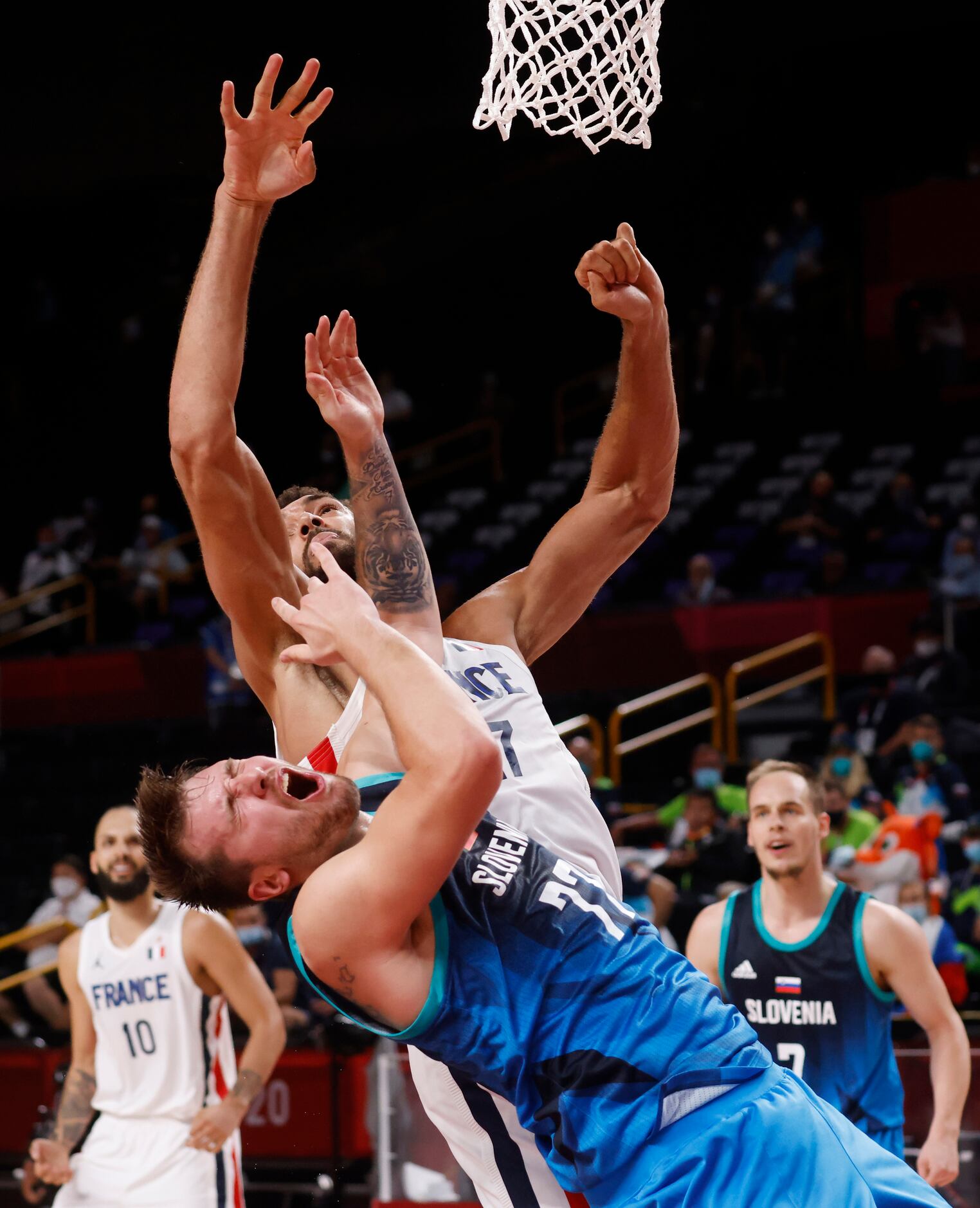 Slovenia’s Luka Doncic (77) is hit in the face by France’s Rudy Gobert (27) during the...
