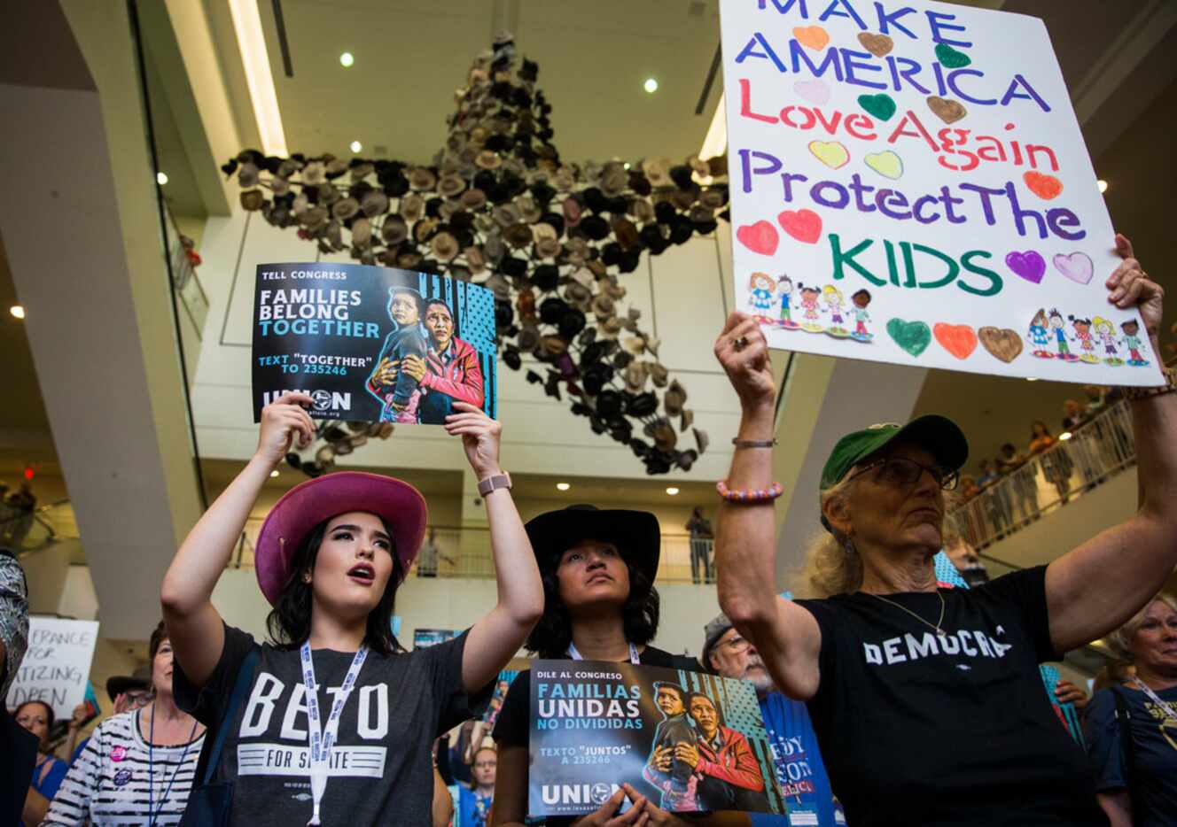Molly Chambers, left, Ashly Ibarra, center, and Cathy Clark chant and hold signs  during a...