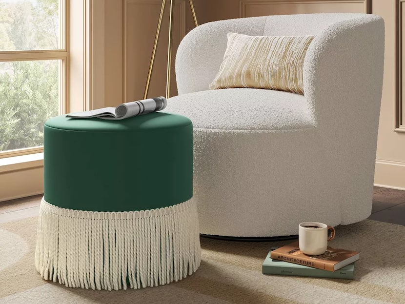 Velvet green ottoman by white chair