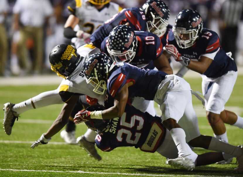 Ryan defenders Delano Robinson (10), Randy Gray (1) and Ra Heem Shaw (25) gang tackle...