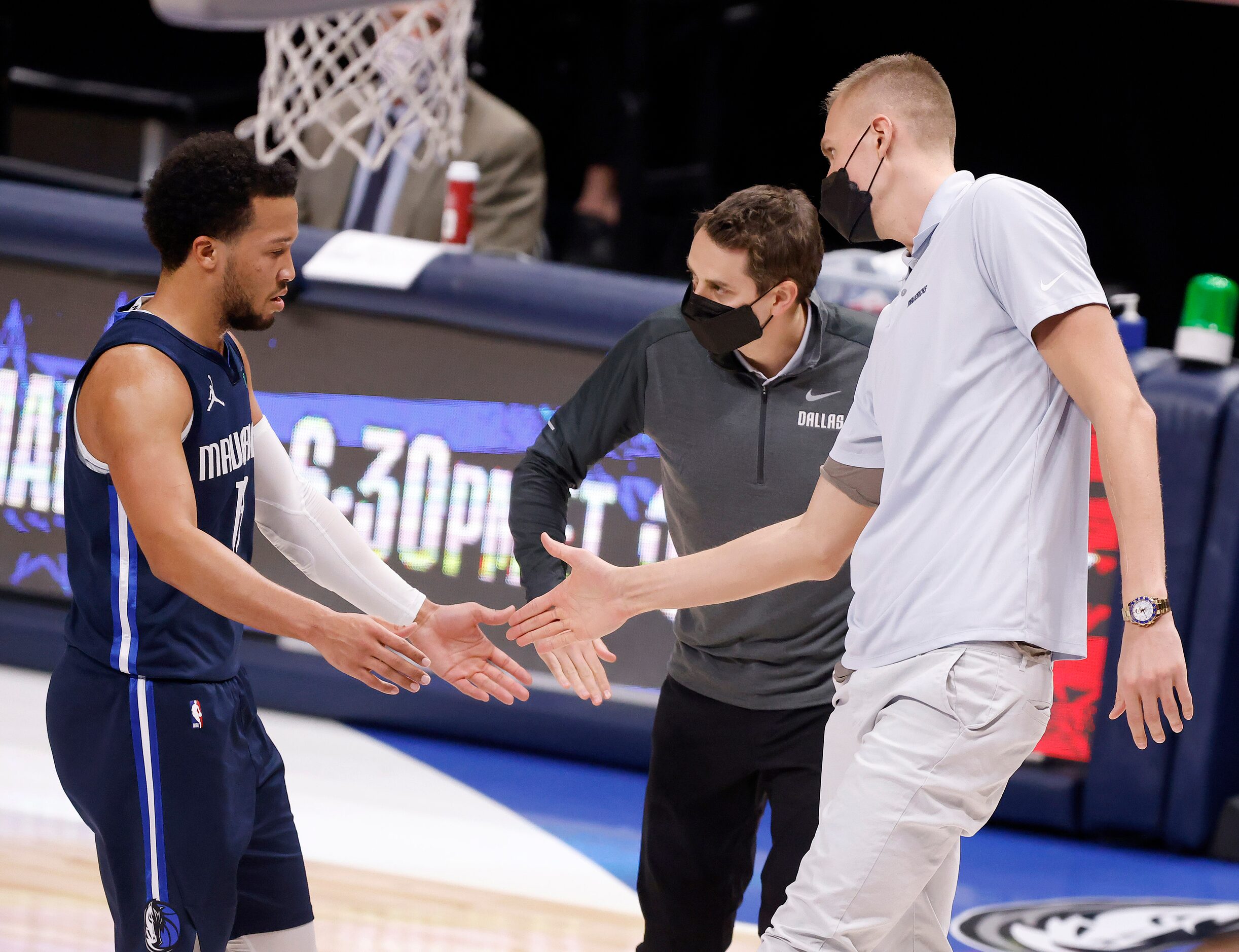 Dallas Mavericks injured center Kristaps Porzingis (right) congratulates guard Jalen Brunson...