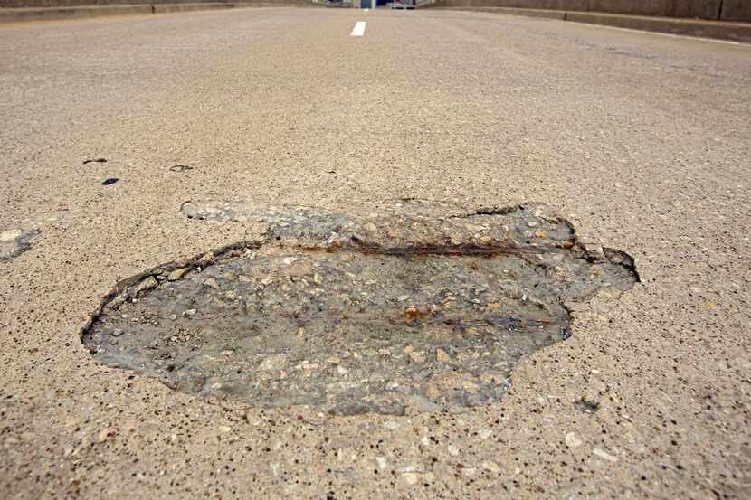A pothole lies  in wait for an unsuspecting motorist in South Dallas. Pothole numbers have...