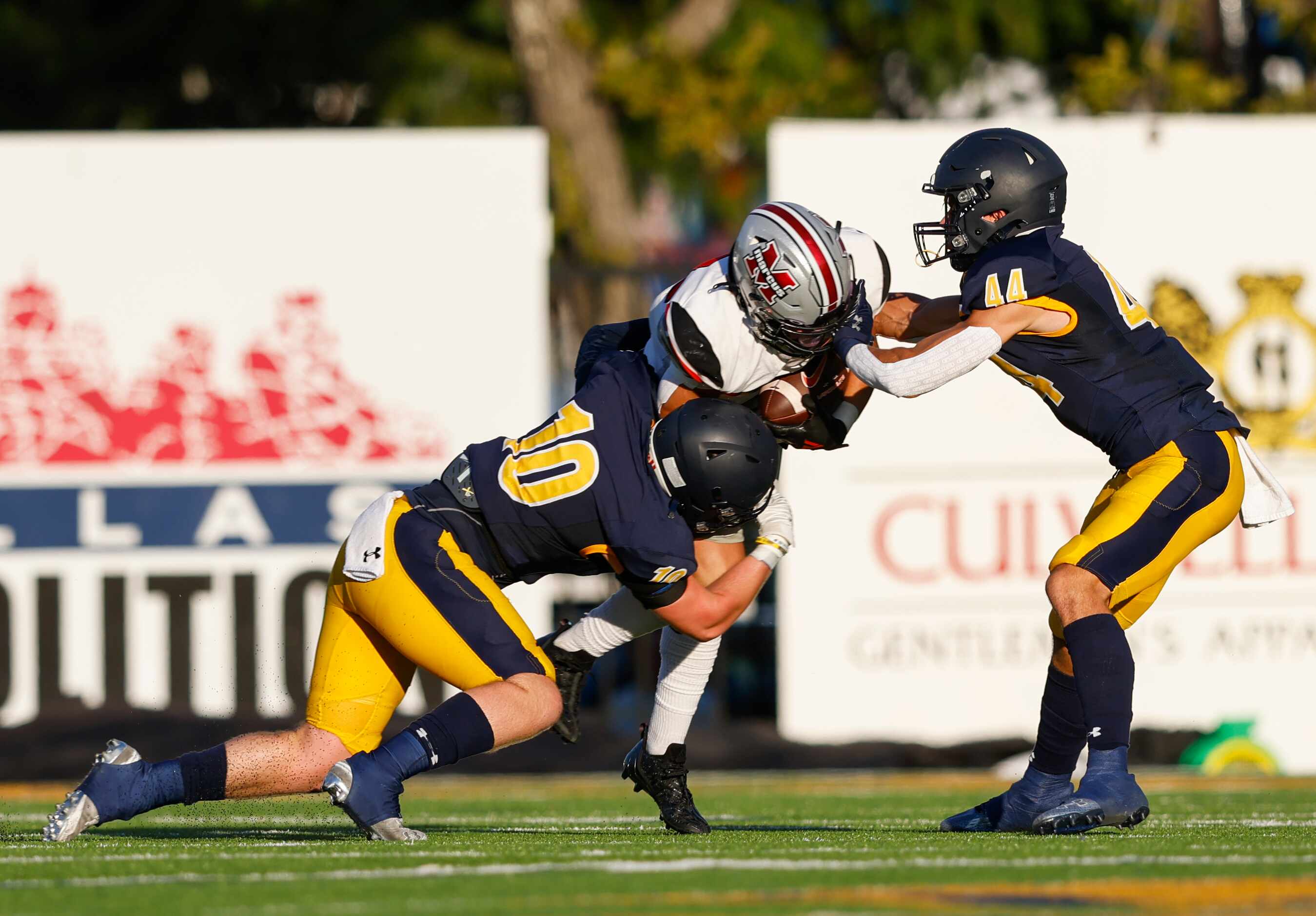 Highland Park’s Robert Rehme (10) and Charlie Barton (44) bring down Flower Mound Marcus’...