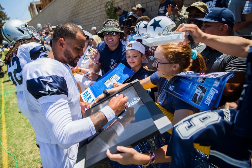 Dallas Cowboys quarterback Dak Prescott (4) signs autographs for fans during a morning...