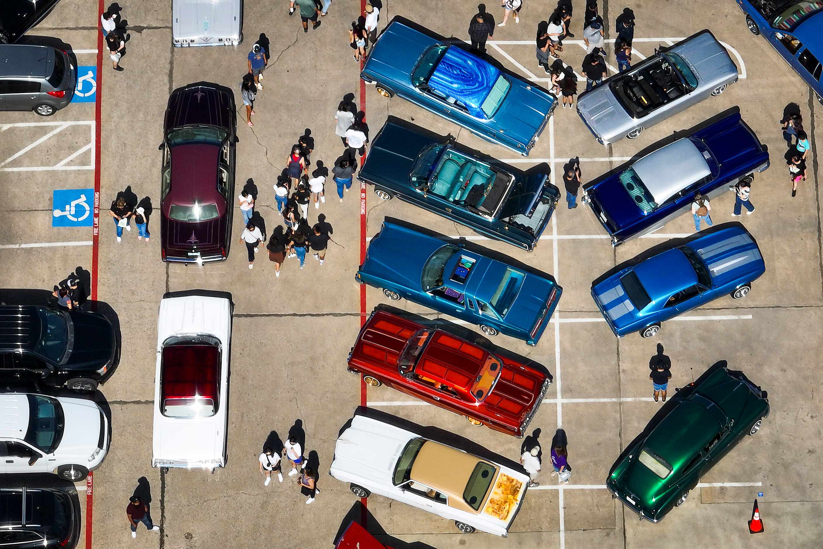 Visitors check out cars on display from the Dallas Lowriders car club during the 214Selena...