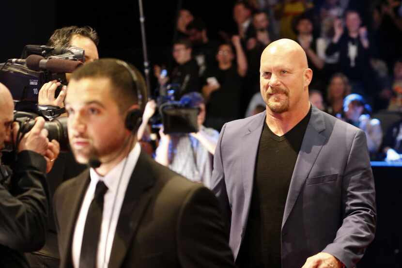Stone Cold Steve Austin, right, arrives at a red carpet during the WWE Hall of Fame event at...