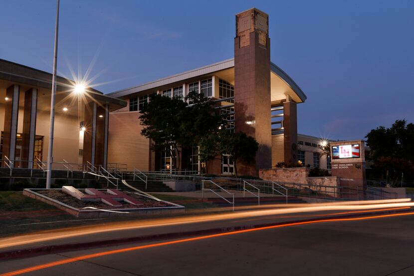 Car lights streak down the main driveway of Lake Highlands High School in Dallas on Aug. 28,...