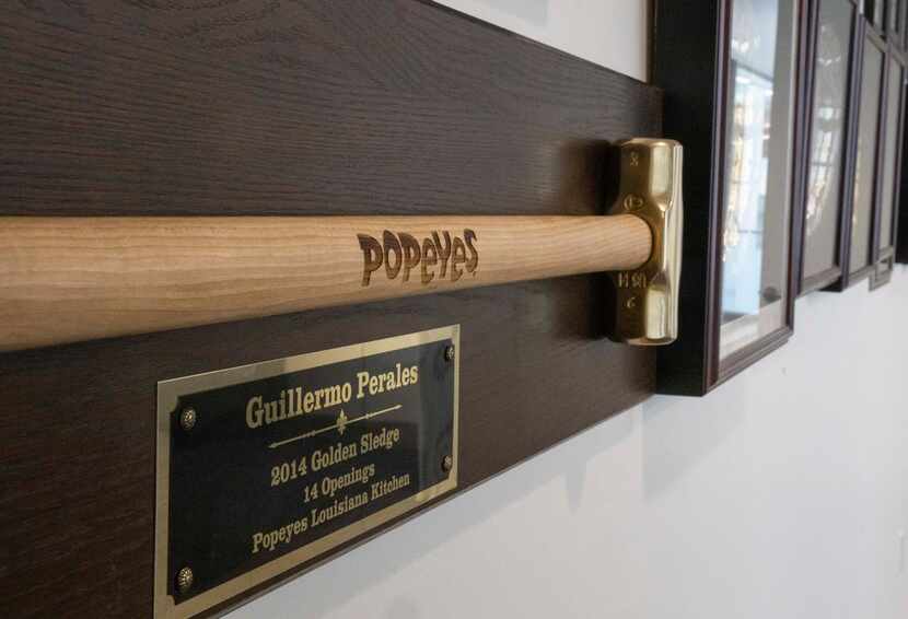 A Golden Sledge hangs on the wall along with Guillermo Perales' other awards at Sun Holdings...