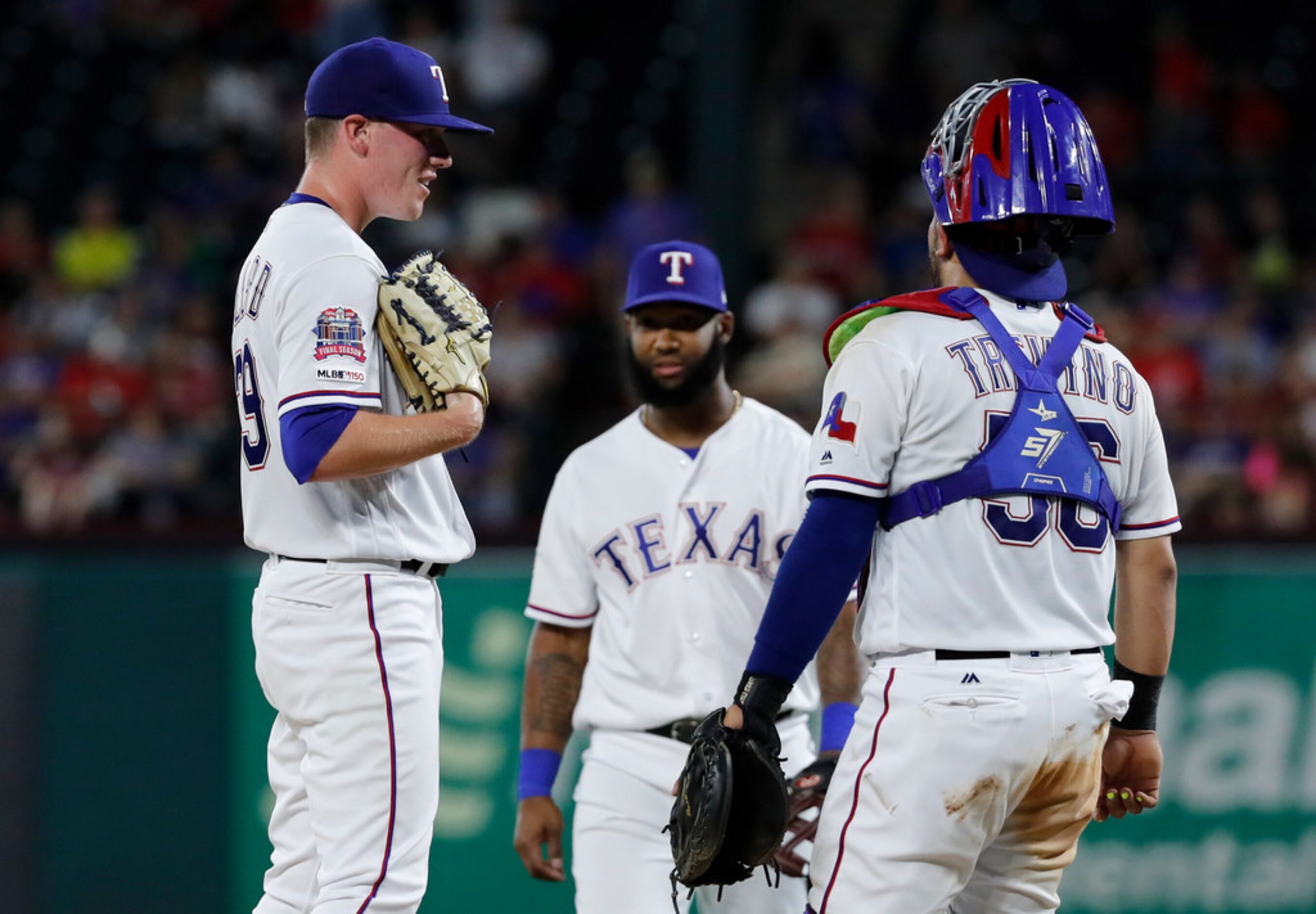 Texas Rangers starting pitcher Kolby Allard (39) stands on the mound smiling at catcher Jose...