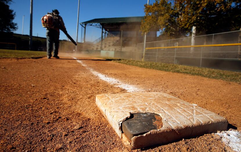 Lawrence Willie of the Dallas Park and Recreation Department uses a leaf blower to clean...