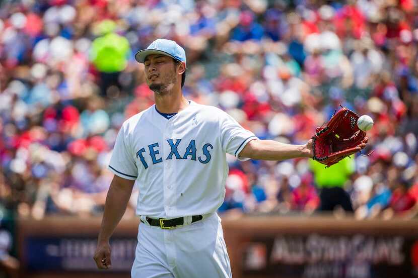 Texas Rangers starting pitcher Yu Darvish gets a new ball after giving up a two-run home run...