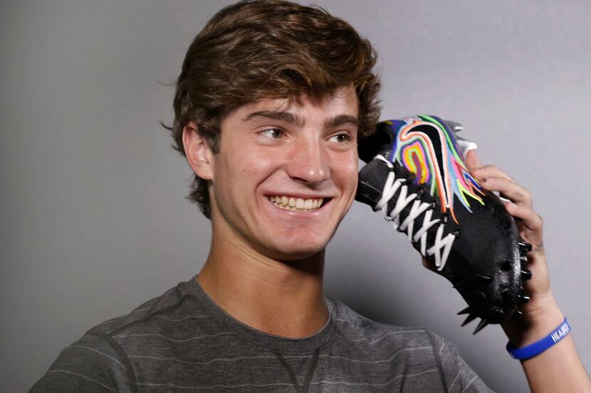 Luke Savage, 16, jokes around after spending about five hours painting a pair of cleats for...