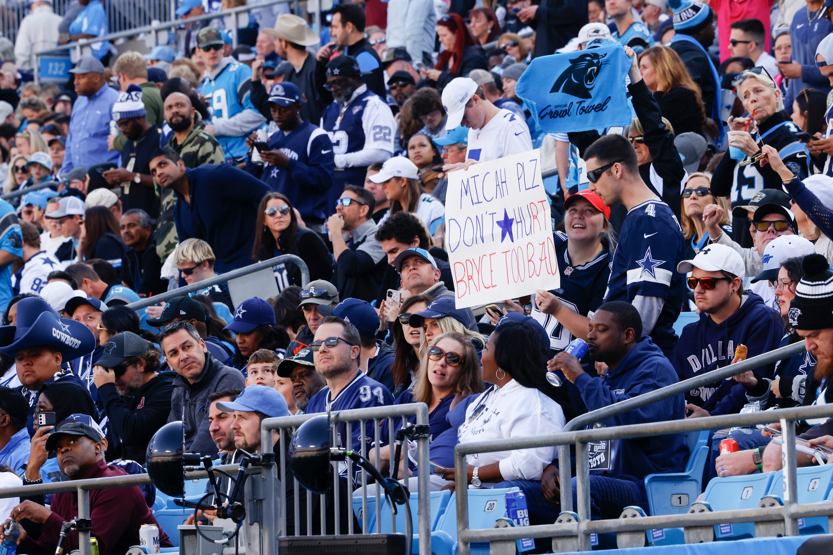 Dallas Cowboys fans hold a sign that reads “Micah plz don’t hurt Bryce too bad” during the...
