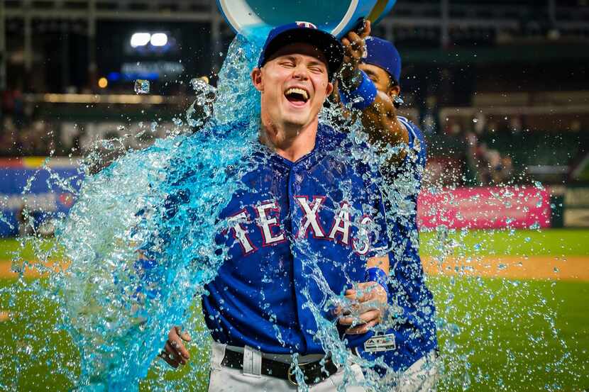 Texas Rangers outfielder Scott Heineman is doused by shortstop Elvis Andrus after the...