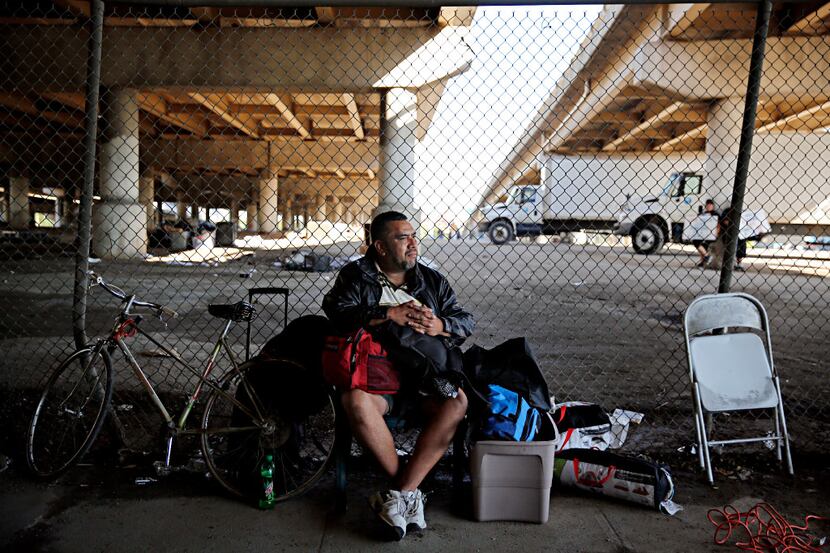 A man who called himself "J.R." sits with his belongings outside the now gated Tent City...
