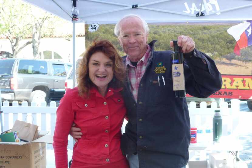 Texas Olive Ranch owner-farmer Jim Henry, with Georgann Rosamund, offers items at St....