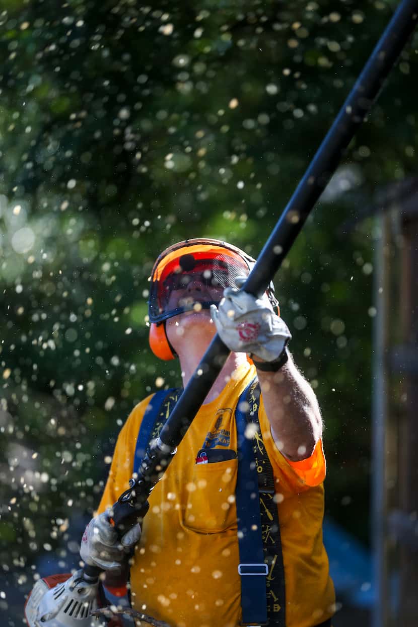 David Talbott, a member of Texas Baptist Men, helps remove trees from a home on Monday,...