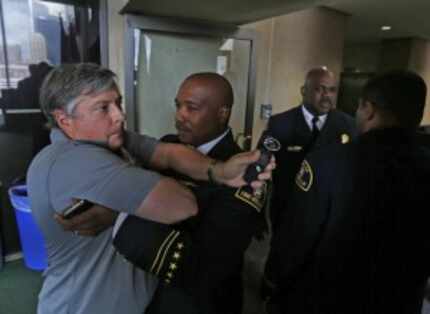  Lt. Joel Lavender (center) restrained LP Phillips, a KRLD reporter, from following Fire...