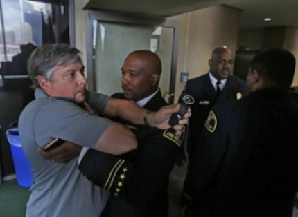  Lt. Joel Lavender (center) restrained LP Phillips, a KRLD reporter, from following Fire...