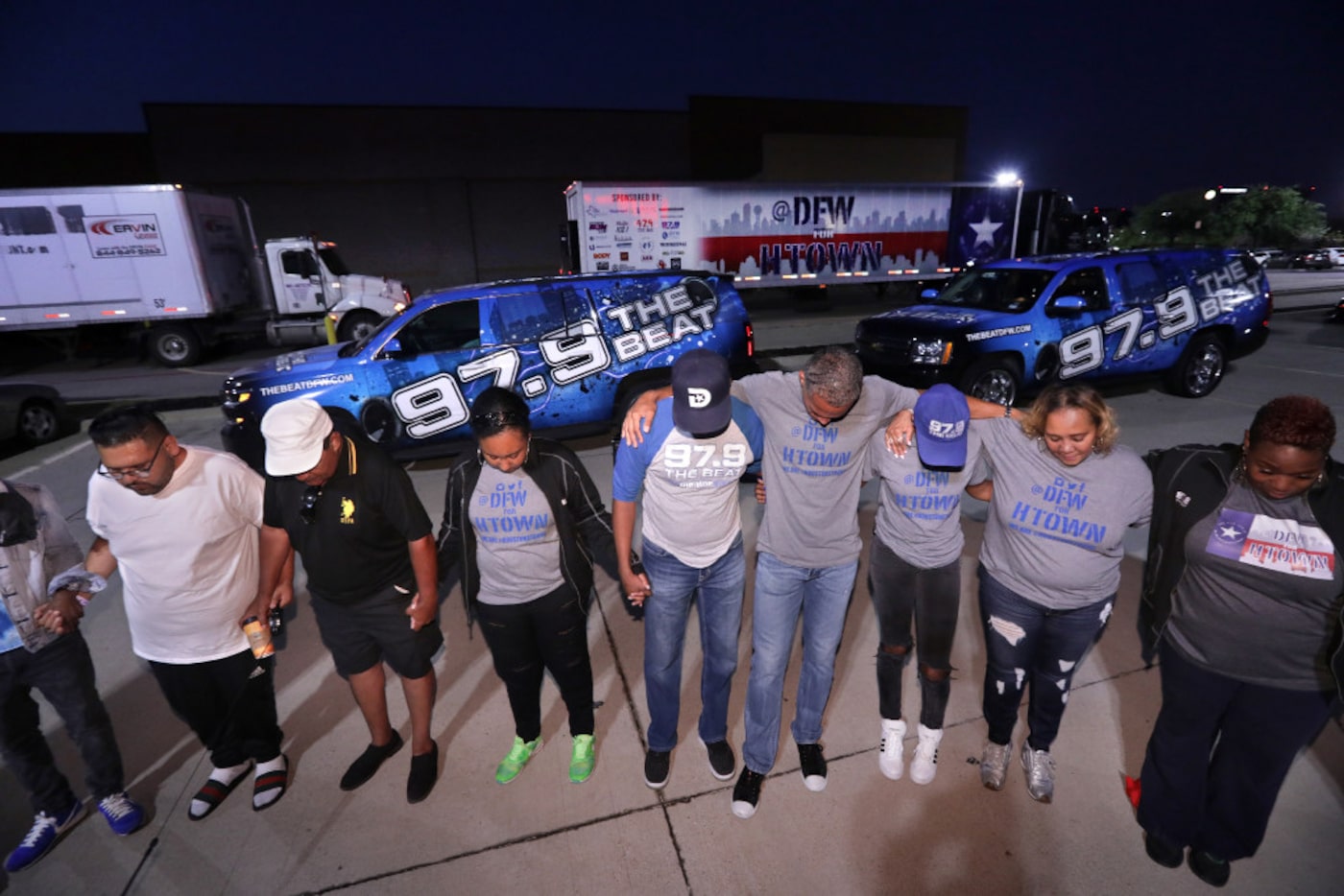 Volunteers hold a group prayer before the caravan of cars, trucks, and motorcycles left for...