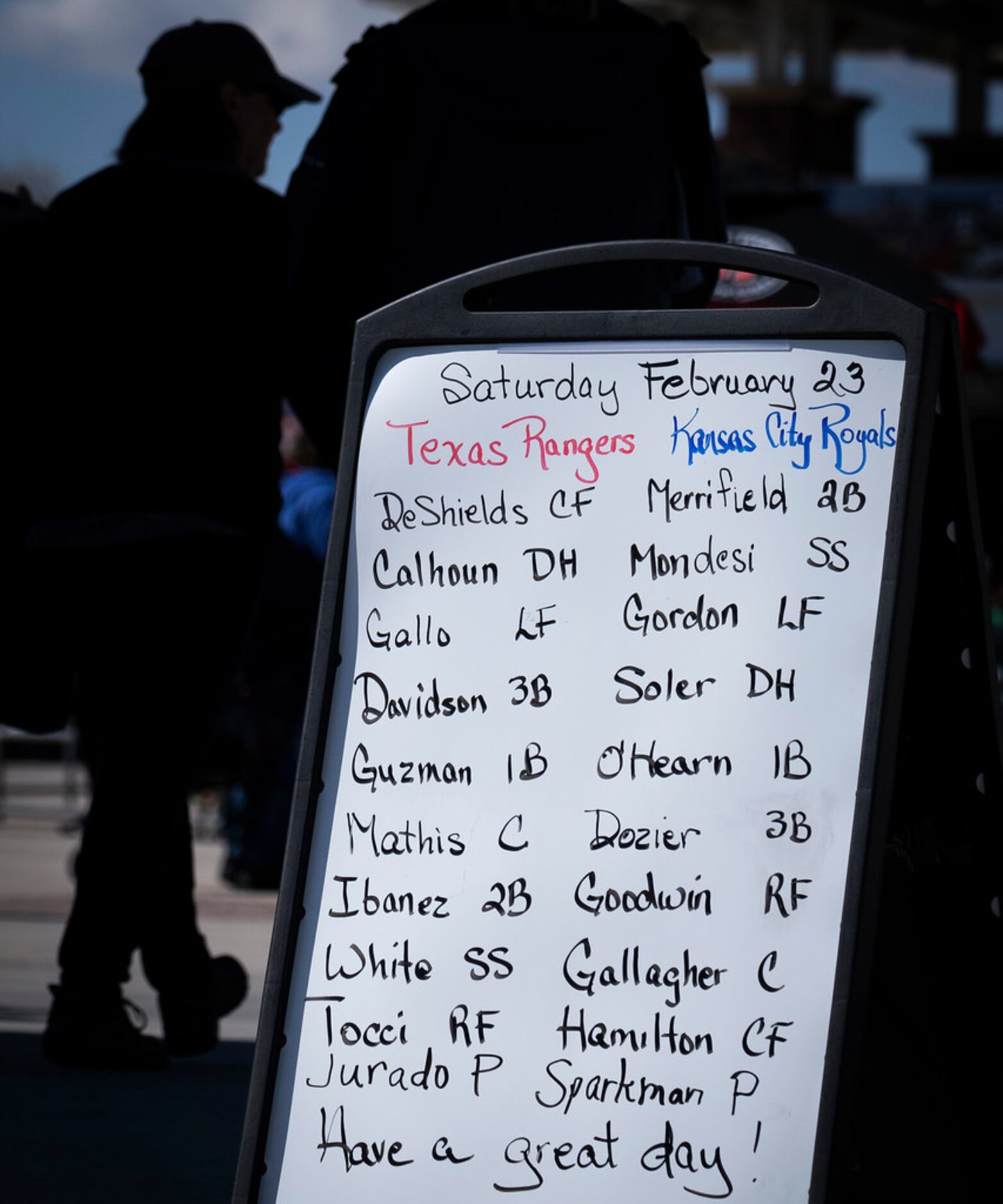 Fans pass the day's starting lineups as they arrive at Surprise Stadium for a spring...