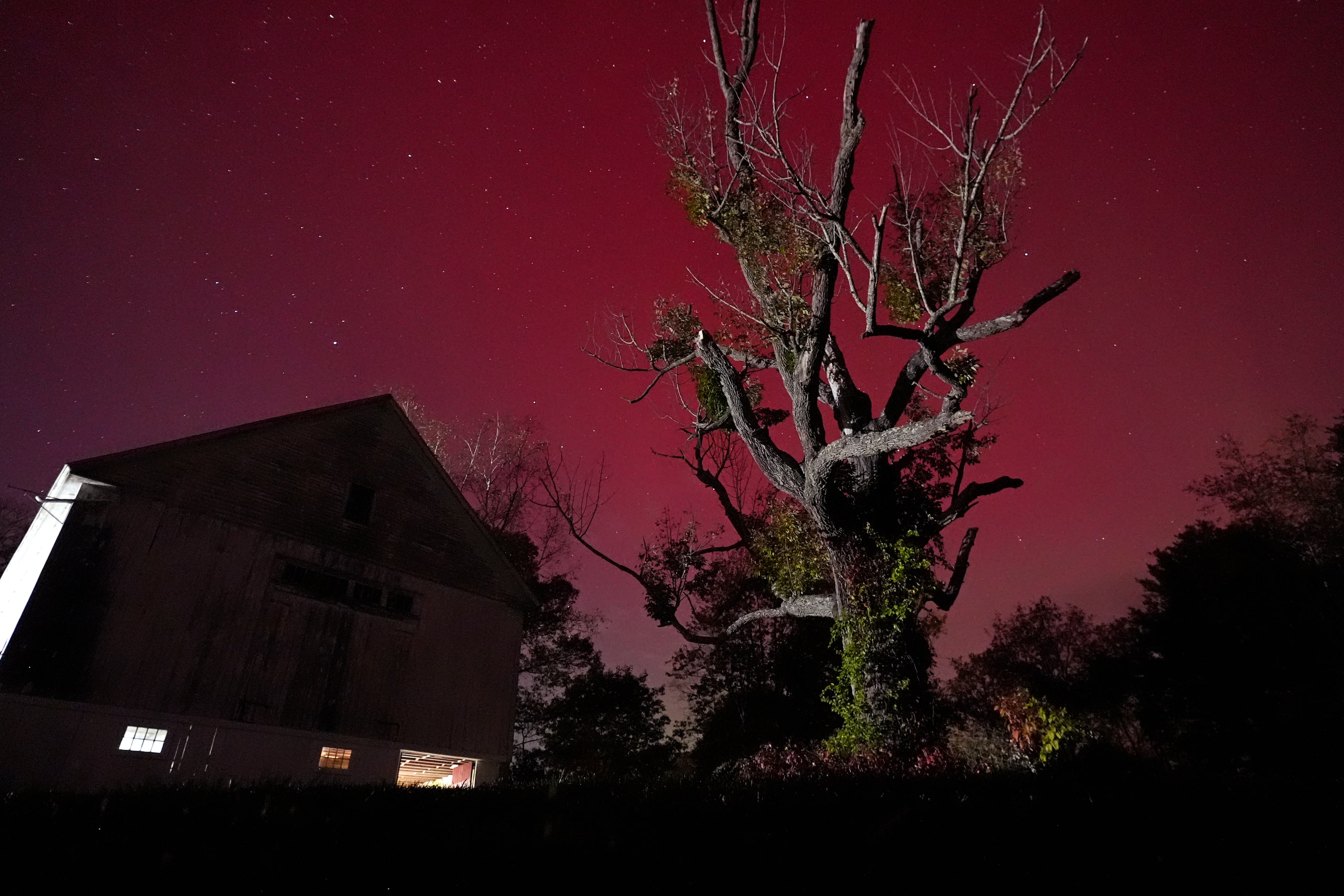 An aurora borealis glows above a barn in East Derry, N.H., on Thursday, Oct. 10, 2024, in...