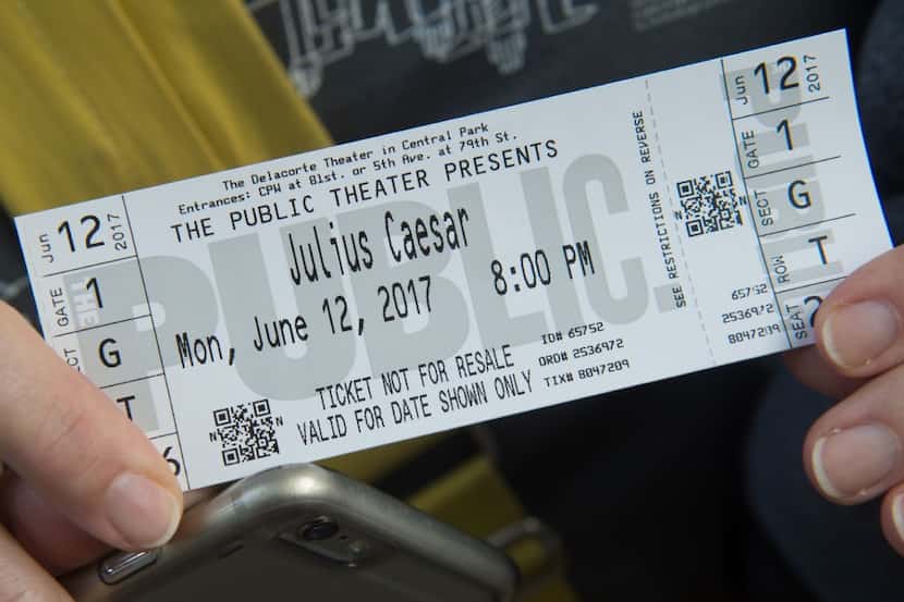 A woman holds her ticket to opening night of Shakespeare in the Park's production of Julius...